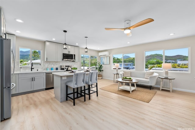 1076 Kahili St, Kailua, HI 96734 - kitchen with stainless steel appliances, a wall unit AC, recessed lighting, decorative backsplash, and a breakfast bar