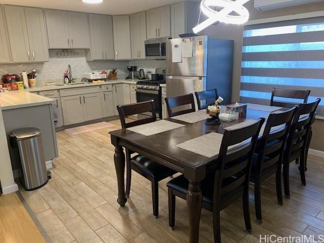 3395 Hardesty St, Honolulu, HI 96816 - dining room featuring light wood-type flooring, a wall mounted air conditioner, and a chandelier