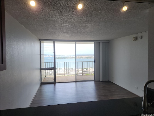 98-099 Uao Pl Unit Ph5, Aiea, HI 96701 - unfurnished room featuring a wall of windows, wood finished floors, a water view, and a textured ceiling