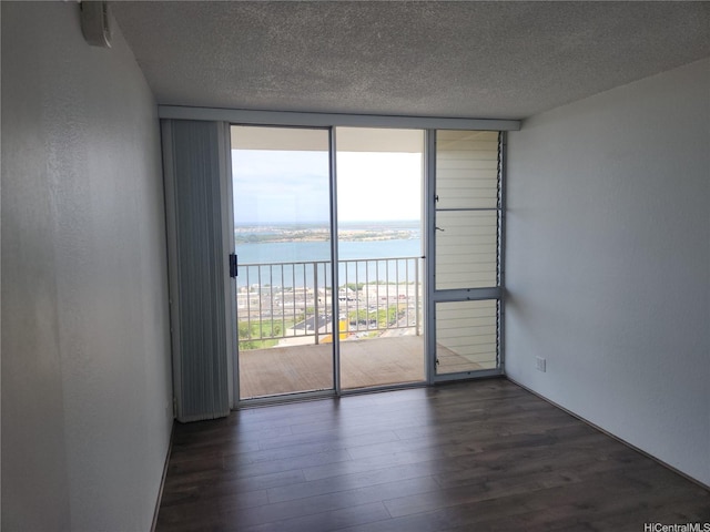 98-099 Uao Pl Unit Ph5, Aiea, HI 96701 - unfurnished room featuring a wall of windows, a water view, a textured ceiling, and dark wood finished floors