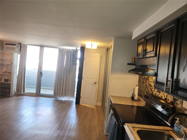 824 Kinau St Unit 403, Honolulu, HI 96813 - kitchen featuring stainless steel electric range oven, wall chimney range hood, a wall mounted AC, tasteful backsplash, and light wood-type flooring