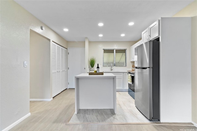 98-467 Hookanike St Unit 758, Pearl City, HI 96782 - kitchen with freestanding refrigerator, a kitchen island, range with electric stovetop, light wood finished floors, and light countertops