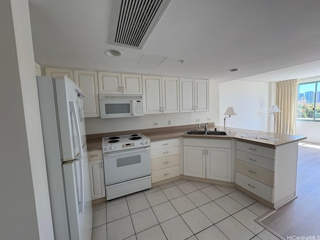 1314 Kalakaua Ave Unit 304, Honolulu, HI 96826 - kitchen featuring white appliances, a peninsula, light tile patterned floors, white cabinets, and recessed lighting