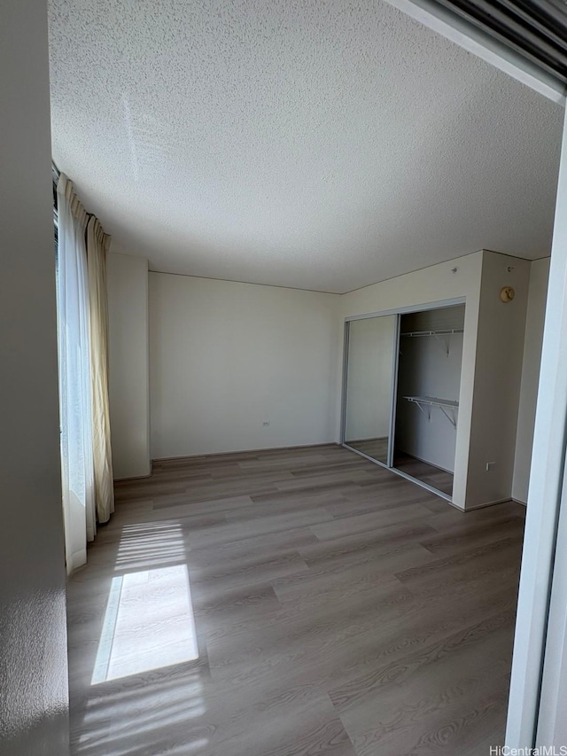1314 Kalakaua Ave Unit 304, Honolulu, HI 96826 - spare room with a textured ceiling and light wood-style flooring