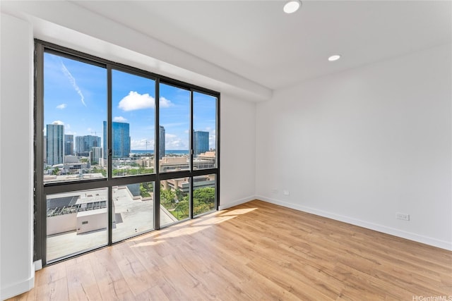700 Richards St Unit 1709, Honolulu, HI 96813 - unfurnished room featuring a skyline view, light wood-style floors, recessed lighting, and floor to ceiling windows
