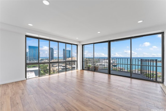 700 Richards St Unit 1709, Honolulu, HI 96813 - unfurnished room featuring a water view, healthy amount of natural light, a wall of windows, wood finished floors, and recessed lighting