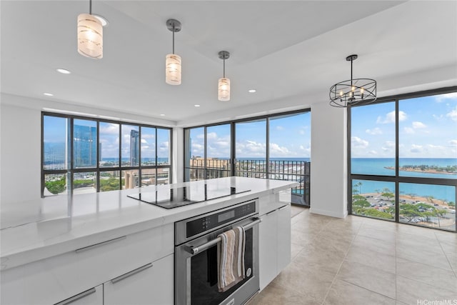 700 Richards St Unit 1709, Honolulu, HI 96813 - kitchen featuring stainless steel oven, black electric cooktop, white cabinetry, hanging light fixtures, and plenty of natural light