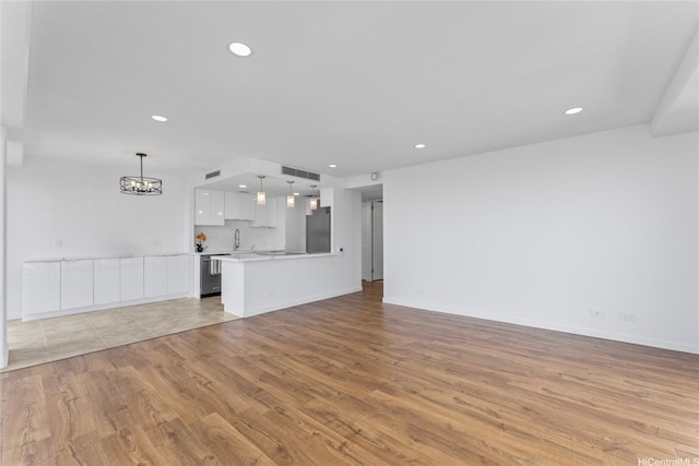 700 Richards St Unit 1709, Honolulu, HI 96813 - unfurnished living room with light wood finished floors, a chandelier, and recessed lighting