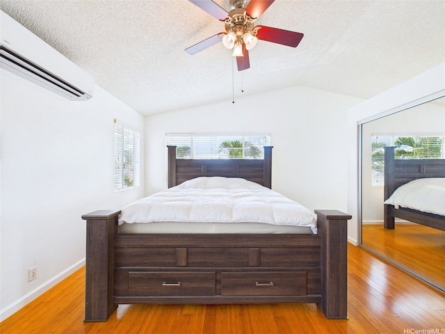 91-2037 Pahuhu Pl, Ewa Beach, HI 96706 - bedroom featuring a wall mounted AC, wood finished floors, multiple windows, a textured ceiling, and vaulted ceiling