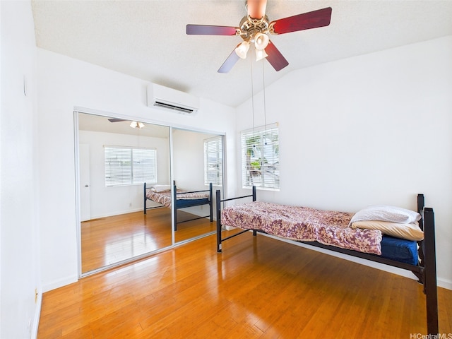 91-2037 Pahuhu Pl, Ewa Beach, HI 96706 - bedroom with an AC wall unit, multiple windows, lofted ceiling, a closet, and light wood-style flooring