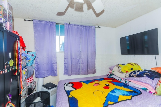 94-049 Waipahu St Unit 308, Waipahu, HI 96797 - bedroom with a textured ceiling, a ceiling fan, and concrete block wall