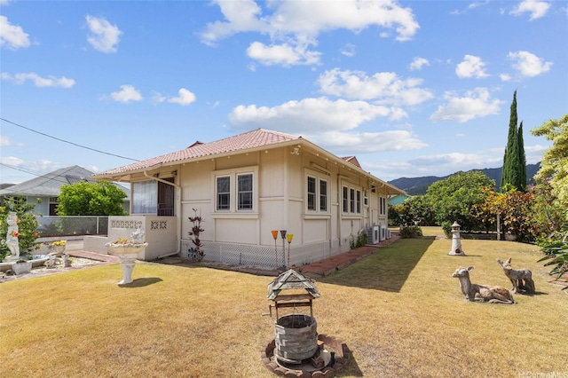 67-186 Kanoena St, Waialua, HI 96791 - view of front of home with a front yard, a tiled roof, a mountain view, and a fire pit