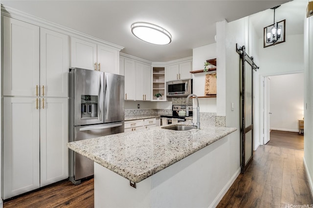 585 Mananai Pl Unit 26U, Honolulu, HI 96818 - kitchen with open shelves, appliances with stainless steel finishes, a barn door, a peninsula, and white cabinetry