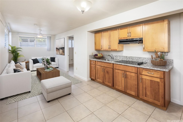 4134 Likini St, Honolulu, HI 96818 - kitchen featuring black electric stovetop, under cabinet range hood, light stone countertops, and light tile patterned flooring
