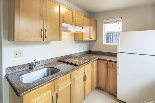 4134 Likini St, Honolulu, HI 96818 - kitchen with freestanding refrigerator, under cabinet range hood, dark stone counters, stovetop, and light brown cabinetry