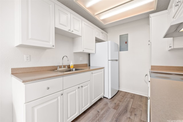 94-1369 Kulewa Loop Unit 14B, Waipahu, HI 96797 - kitchen featuring range, freestanding refrigerator, electric panel, light wood finished floors, and white cabinetry