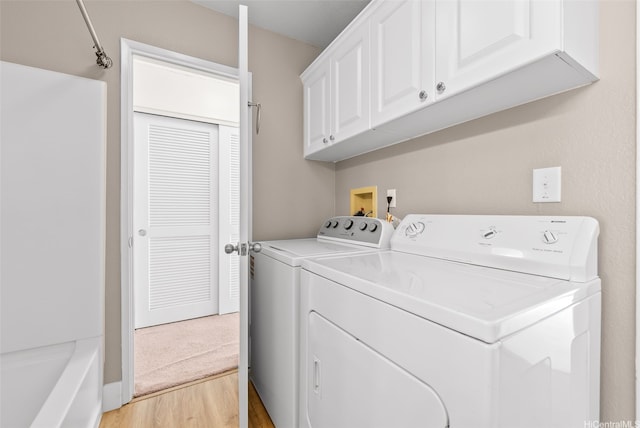 94-1369 Kulewa Loop Unit 14B, Waipahu, HI 96797 - laundry area featuring washer and clothes dryer, light wood-style floors, and cabinet space