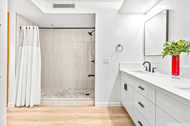 1330 Ala Moana Blvd Unit 1907, Honolulu, HI 96814 - bathroom featuring a tile shower, double vanity, and wood finished floors