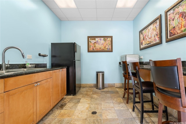 430 Kaiolu St Unit 505, Honolulu, HI 96815 - kitchen featuring freestanding refrigerator, a drop ceiling, dark stone countertops, and stone finish flooring