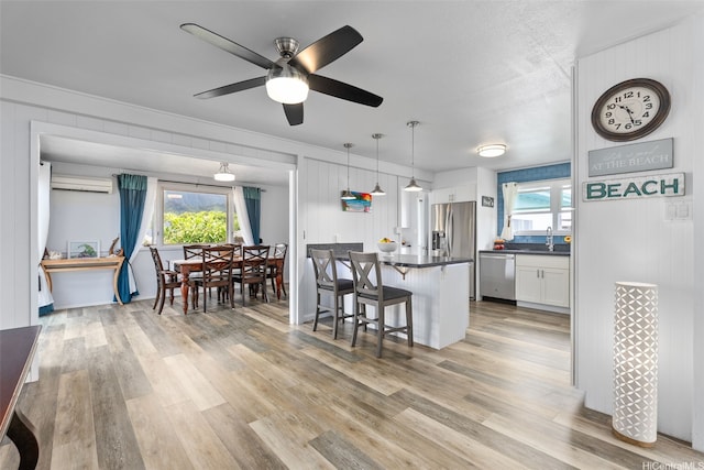 46-146 Hinalani Pl, Kaneohe, HI 96744 - kitchen featuring stainless steel appliances, dark countertops, a kitchen breakfast bar, white cabinets, and plenty of natural light