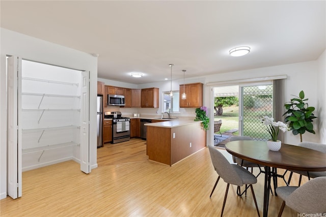 95-246 Wailawa St, Mililani, HI 96789 - kitchen with appliances with stainless steel finishes, light wood-type flooring, a peninsula, brown cabinetry, and light countertops