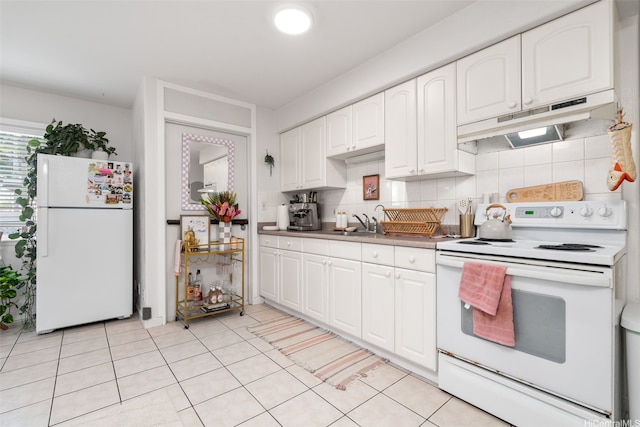 1607 Makiki St Unit B, Honolulu, HI 96822 - kitchen featuring white appliances, under cabinet range hood, tasteful backsplash, white cabinetry, and light tile patterned flooring
