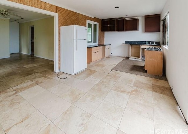 73-4154 Kahauli Pl, Kailua Kona, HI 96740 - kitchen with freestanding refrigerator, wallpapered walls, a ceiling fan, dark countertops, and dark brown cabinets