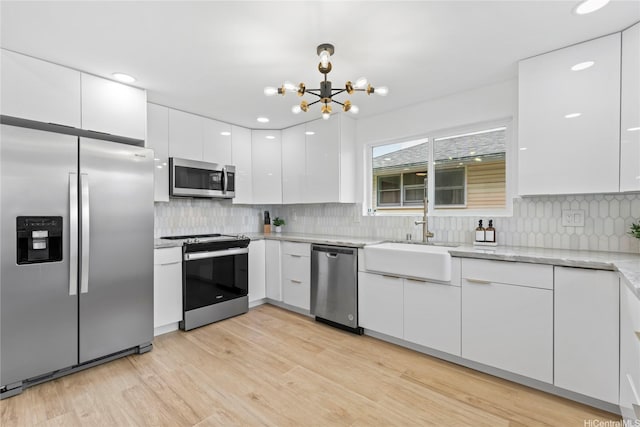 115A Makaweo St, Wahiawa, HI 96786 - kitchen with appliances with stainless steel finishes, white cabinetry, modern cabinets, a chandelier, and light stone countertops