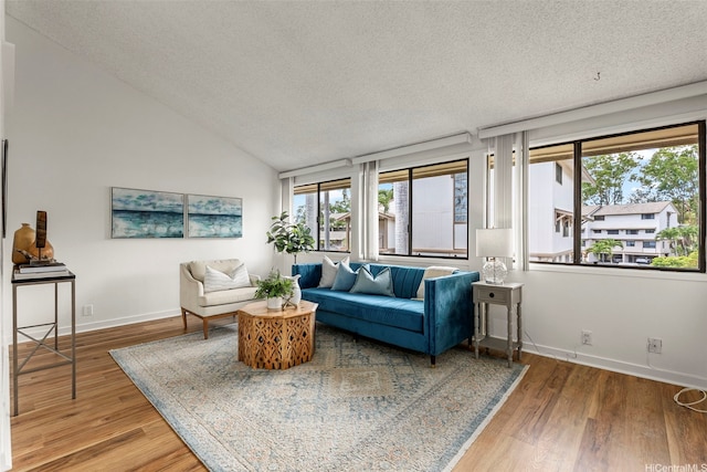 95-138 Kuahelani Ave Unit 244, Mililani, HI 96789 - living room with healthy amount of natural light, a textured ceiling, wood finished floors, and lofted ceiling