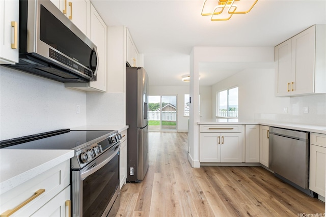 94-615 Lumiaina St, Waipahu, HI 96797 - kitchen featuring appliances with stainless steel finishes, light wood-style flooring, light countertops, and white cabinets