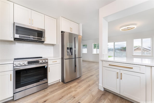 94-615 Lumiaina St, Waipahu, HI 96797 - kitchen featuring stainless steel appliances, light countertops, light wood-style flooring, and white cabinetry