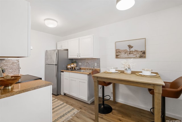 3370 Salt Lake Blvd Unit 204, Honolulu, HI 96818 - kitchen featuring freestanding refrigerator, white cabinets, light wood-type flooring, and backsplash