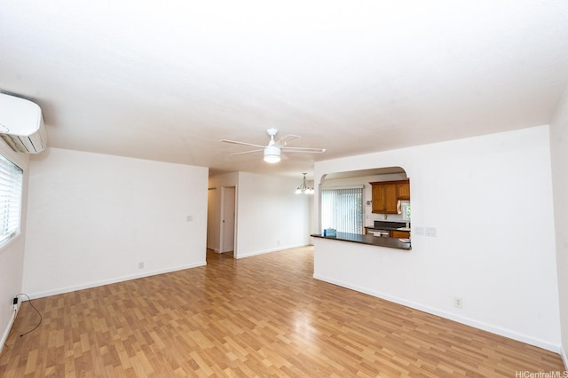 94-725 Kumau Pl, Waipahu, HI 96797 - unfurnished living room with light wood-style flooring, a ceiling fan, a wall unit AC, arched walkways, and a chandelier