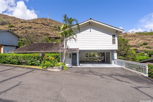 view of front of home with a carport, driveway, and a mountain view