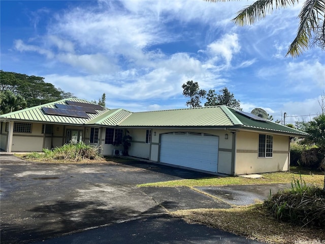 16-1873 34th Ave, Keaau, HI 96749 - view of front of house featuring driveway, a garage, solar panels, and a metal roof