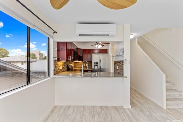 1418 Makiki St Unit A, Honolulu, HI 96814 - kitchen featuring stainless steel appliances, an AC wall unit, decorative backsplash, and light wood finished floors