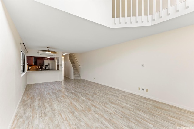 1418 Makiki St Unit A, Honolulu, HI 96814 - unfurnished living room with stairs, light wood-style flooring, and a ceiling fan