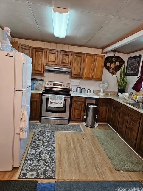 3844 Likini St, Honolulu, HI 96818 - kitchen featuring stainless steel range with electric cooktop, freestanding refrigerator, under cabinet range hood, and light countertops