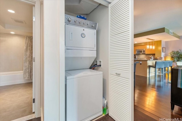 1837 Kalakaua Ave Unit 808, Honolulu, HI 96815 - laundry area with stacked washing machine and dryer, recessed lighting, and wood finished floors
