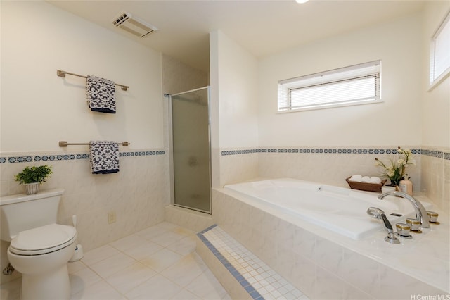 92-1318 Hauone St, Kapolei, HI 96707 - bathroom featuring a bath, an enclosed shower, tile patterned floors, wainscoting, and tile walls