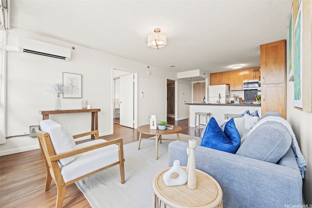 1133 Waimanu St Unit 2503, Honolulu, HI 96814 - living room with a wall mounted air conditioner, a textured ceiling, and wood finished floors