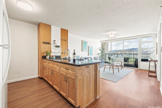 1133 Waimanu St Unit 2503, Honolulu, HI 96814 - kitchen with open floor plan, a textured ceiling, a peninsula, wood finished floors, and freestanding refrigerator