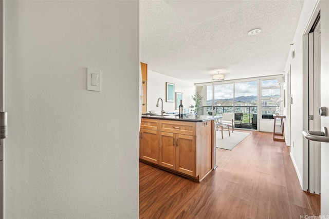 1133 Waimanu St Unit 2503, Honolulu, HI 96814 - kitchen featuring dark wood-style floors, dark countertops, a textured ceiling, open floor plan, and brown cabinetry