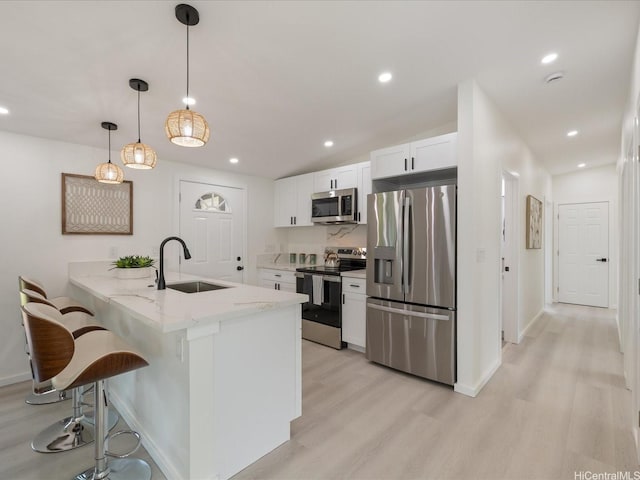 2078 Akaikai Loop, Pearl City, HI 96782 - kitchen featuring stainless steel appliances, light wood-style floors, a kitchen breakfast bar, white cabinets, and a peninsula