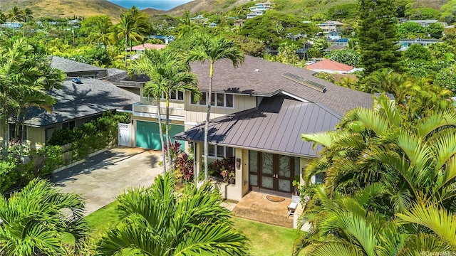 1319 Mokulua Dr, Kailua, HI 96734 - back of house featuring concrete driveway, a shingled roof, french doors, a mountain view, and a standing seam roof