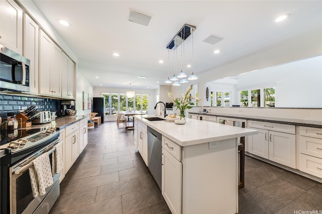 1319 Mokulua Dr, Kailua, HI 96734 - kitchen with stainless steel appliances, plenty of natural light, a kitchen island with sink, recessed lighting, and tasteful backsplash