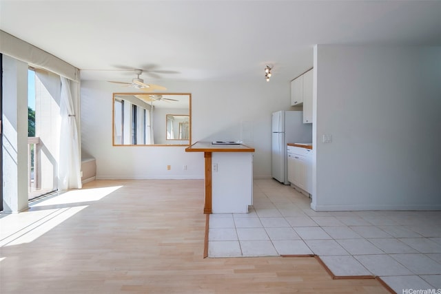 84-755 Ala Mahiku St Unit 74B, Waianae, HI 96792 - kitchen featuring freestanding refrigerator, white cabinets, ceiling fan, light wood-type flooring, and light countertops