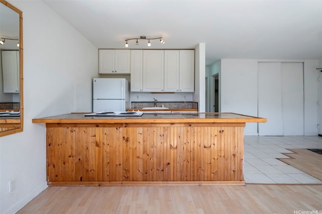 84-755 Ala Mahiku St Unit 74B, Waianae, HI 96792 - kitchen featuring freestanding refrigerator, white cabinetry, light wood-type flooring, a peninsula, and stovetop