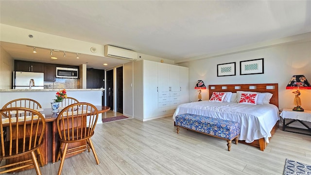 1777 Ala Moana Blvd Unit 2436, Honolulu, HI 96815 - bedroom with a wall mounted air conditioner, freestanding refrigerator, rail lighting, and light wood-style flooring