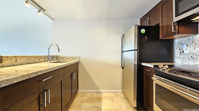 1777 Ala Moana Blvd Unit 2436, Honolulu, HI 96815 - kitchen featuring stainless steel appliances, dark brown cabinetry, light stone countertops, track lighting, and backsplash